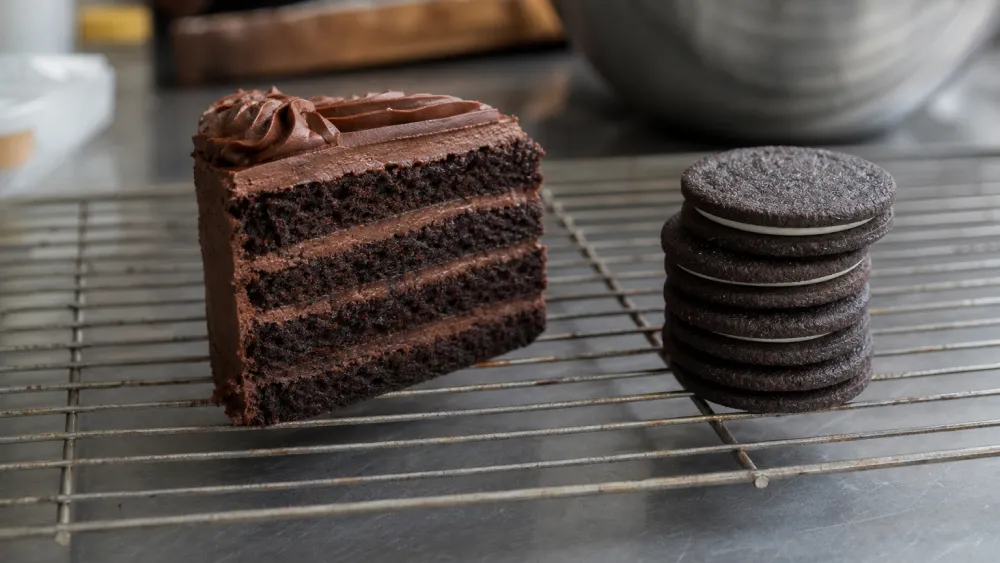 Chocolate cake made with dark cocoa beside black cocoa sandwich cookies