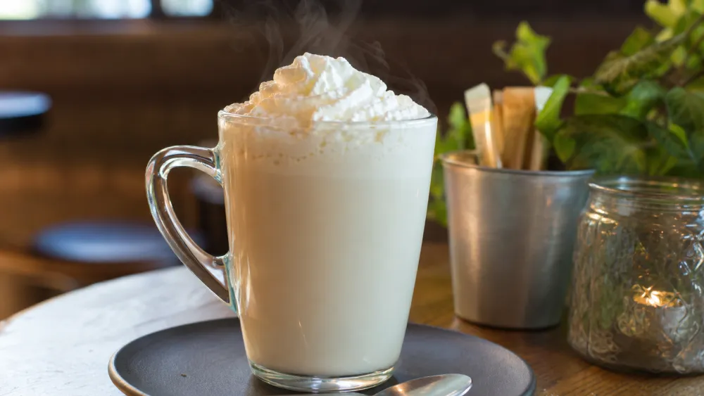 A cup of white hot chocolate topped with cream